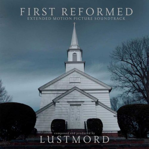 A stark white church stands against a dark, moody sky. The title "First Reformed" is displayed at the top, and the words "Extended Motion Picture Soundtrack" are below. The composer and producer, Lustmord, is credited at the bottom. The image conveys a sense of somber reflection and spiritual contemplation.